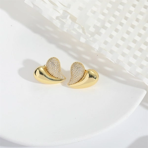 Macro detail of gold heart earrings with half-polished and half-pave rhinestone finish