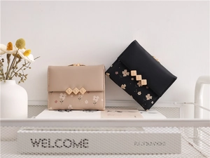 Detailed view of floral print mini wallets in beige and black with vintage kiss-lock clasp