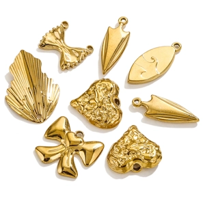 Close-up of golden titanium steel DIY charms including bow, heart, and leaf shapes