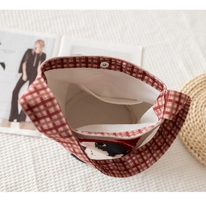 Internal view of red plaid bucket bag with magnetic closure and small inner pocket
