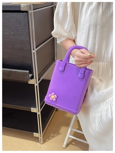 Detail der lila EVA Strandtasche mit matter Textur und süßem Blumenanhänger Zubehör