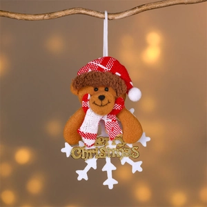 Plush Christmas bear ornament with Merry Christmas text on a snowflake hanging from a branch