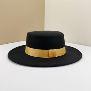 Close-up of a black wool felt flat top boater hat with a vibrant yellow grosgrain ribbon