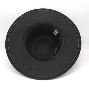 Close-up of black wide brim felt hat interior showing wash care labels and material texture