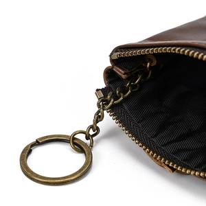 Macro detail of brown leather coin purse with brass zipper and internal key ring chain