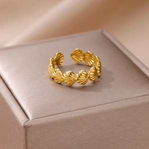 Close-up of golden shell textured adjustable ring on a textured jewelry box