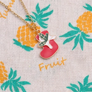 Christmas stocking pendant necklace with gold chain and festive holly bow detail