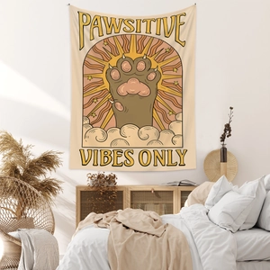 Detail of bohemian cat tapestry with Pawsitive Vibes Only slogan in a cozy bedroom