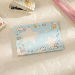 Flat lay of light blue star-patterned notepad with stationery accessories on textured paper