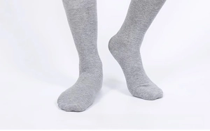 Detail view of heather grey knit cotton socks with ribbed cuffs on model feet