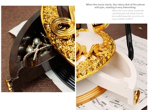 Detail of vintage telephone music box featuring functional jewelry storage and gold motifs