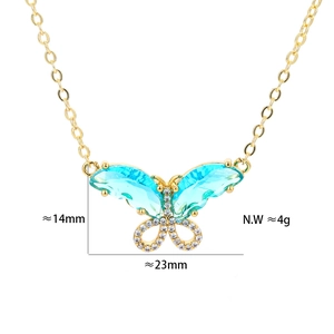 Macro shot of gold butterfly pendant with light blue zircon stones and size measurements
