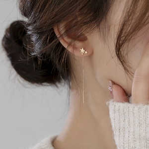 Detail of elegant gold star tassel drop earrings shown on a model for a stylish look