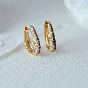 Close-up of gold S925 sterling silver huggie earrings with black and white zircon rows