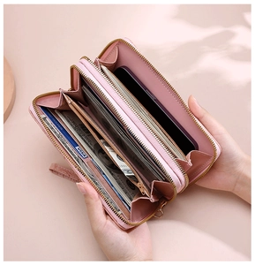 Macro view of a pink leather long wallet featuring dual gold zippers and multi-card slots