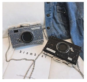 Detail of glitter camera-shaped handbags in silver and black with metal chains