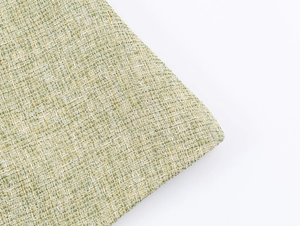 Close-up of green and tan tweed texture with intricate woven fabric craftsmanship