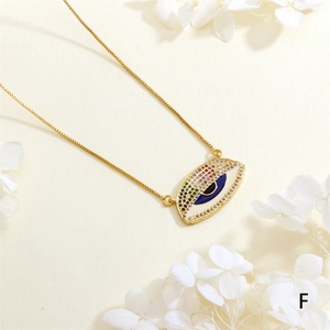 Macro shot of evil eye pendant with blue zircon center and gold box chain detail