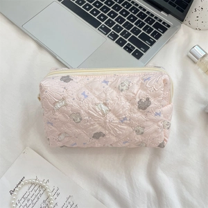 Close-up of pink quilted cosmetic bag featuring cute rabbit prints and beige zipper