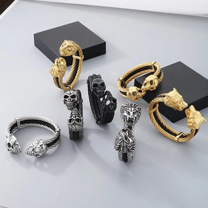 Close-up of punk style lion and wolf head charms on twisted wire steel bracelet