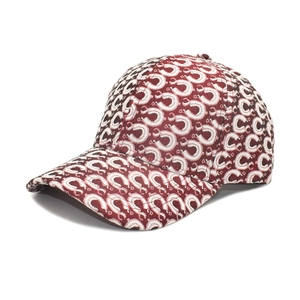Detail of burgundy baseball cap with white and pink abstract pattern and curved brim
