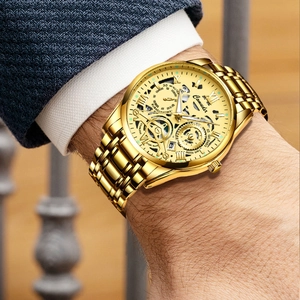 Macro shot of men's hollow dial gold mechanical watch with Roman numerals on wrist