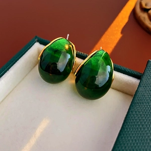 Detailed view of dark green resin teardrop earrings with elegant golden metal edging