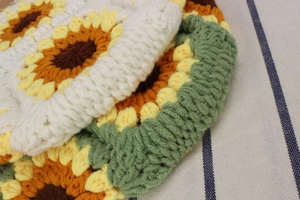 Close-up of handmade crochet sunflower coaster showing intricate knit yarn textures
