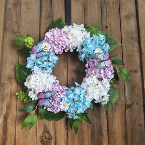 Detailed view of autumn hydrangea wreath with butterflies on vintage wood background