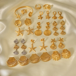 Golden starfish and seashell jewelry set arranged on elegant beige silk fabric