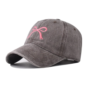 Dettaglio del ricamo a fiocco rosa su cappello da baseball in cotone lavato grigio