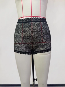 Close-up of black floral lace fabric with intricate rose patterns and scalloped edges