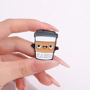 Cute enamel coffee cup brooch with arms and Deja Brew text in a hand-held display view
