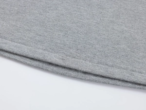 Gros plan sur la couture à double aiguille et le tricot gris haute densité de l'ourlet