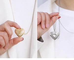 Detailed view of gold and silver heart-shaped locket pendants with floral engravings