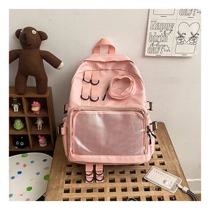 Detailed view of pink nylon backpack featuring a transparent front pocket and large capacity
