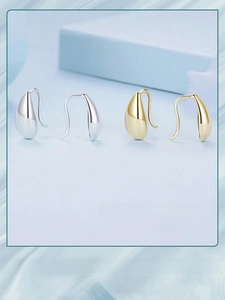 Detail view of teardrop earrings with high gloss finish in silver and gold tones