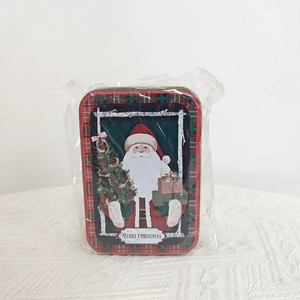 Close-up of rectangular Christmas tin box featuring Santa Claus and Merry Christmas text