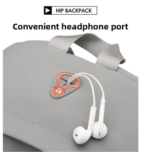Detail of grey backpack featuring a built-in earphone port with white wired headphones
