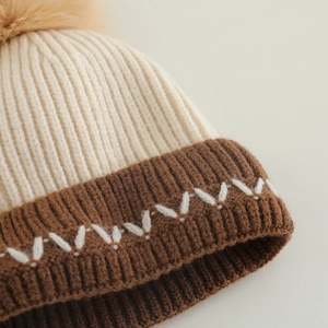 Gestrickte Wintermütze für Kleinkinder mit Kontrastfarben und Kunstpelz-Bommel