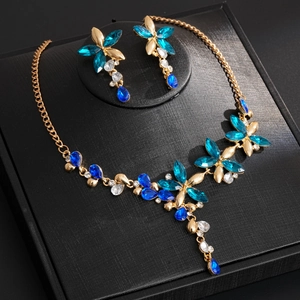 Detailed macro view of vintage gold flower necklace and blue crystal tassel earrings