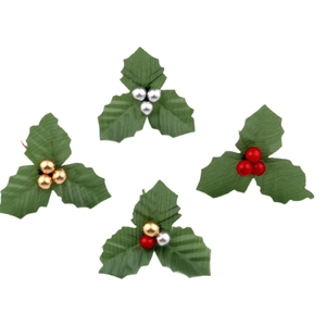 Artificial Christmas holly leaves with red and gold berries on a white background