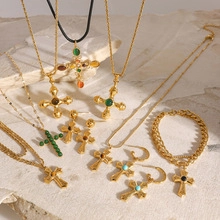 Detailed close-up of retro gold-plated cross necklaces and turquoise earrings on stone