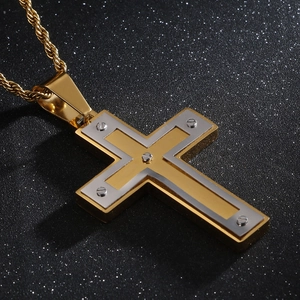 Vue macro d'un pendentif croix bicolore or et argent avec détails de vis et chaîne torsadée
