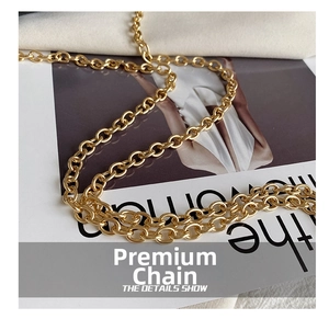 Detail showing high-quality polished gold metal chain strap on a stylish handbag