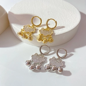 Detailed macro of gold and silver Ruyi lock earrings with micro-pave zircons and bells