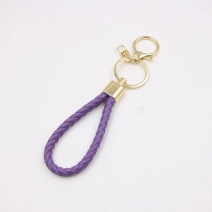 Close-up of purple braided leather keychain with golden metal ring and swivel clasp detail