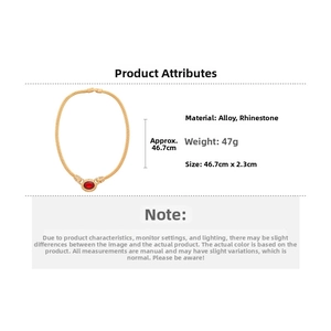 Detail view of gold snake chain necklace with red gemstone and size measurements