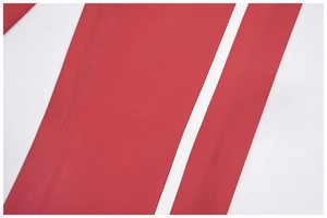 Detail of red high-elastic yoga pants with white side stripes and flatlock stitching