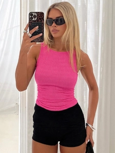 Haut plissé sans manches rose fuchsia et short noir pour un style de rue estival tendance